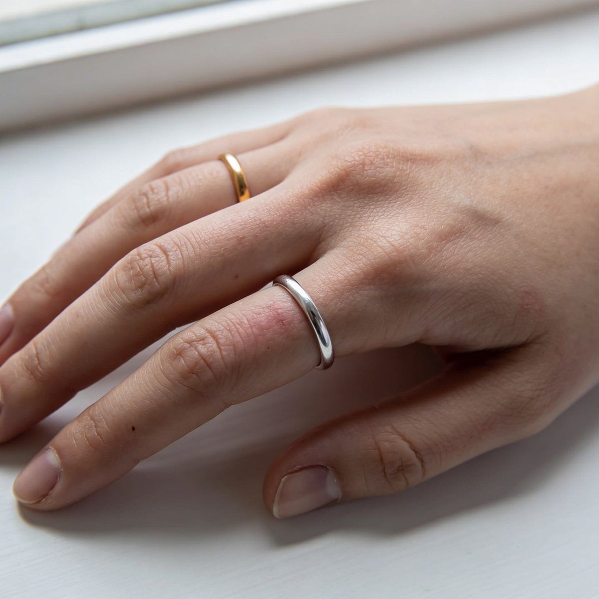 Gold-vs-Silber-Test: goldener und silberner Schmuck nebeneinander auf der Haut zur Bestimmung des Untertons